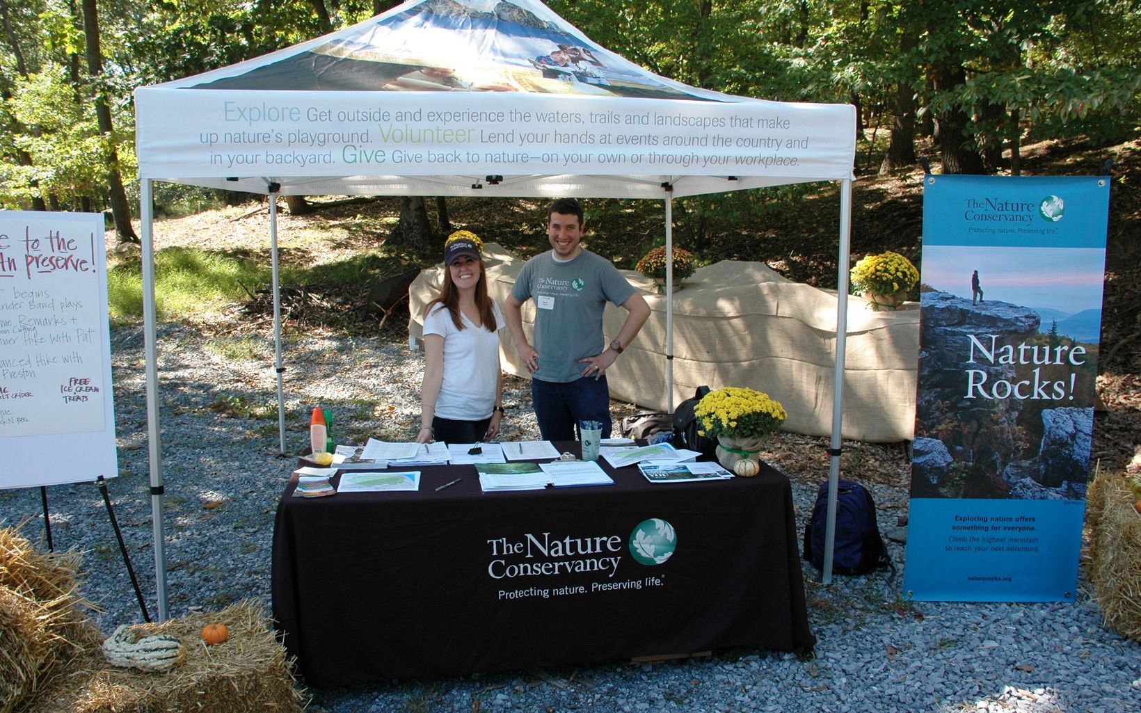 Two TNC staff members stand under a tent.