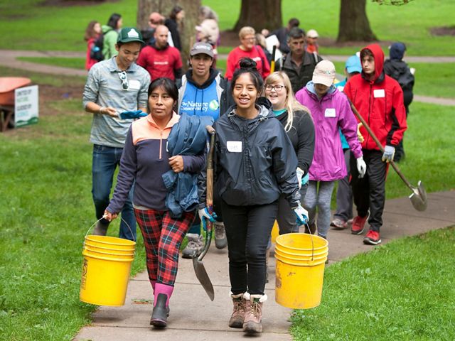 A group of smiling volunteers at Mount Tabor Park in Portland, Oregon.
