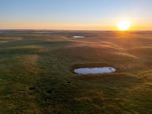 Sunset over a pond in the prairie.