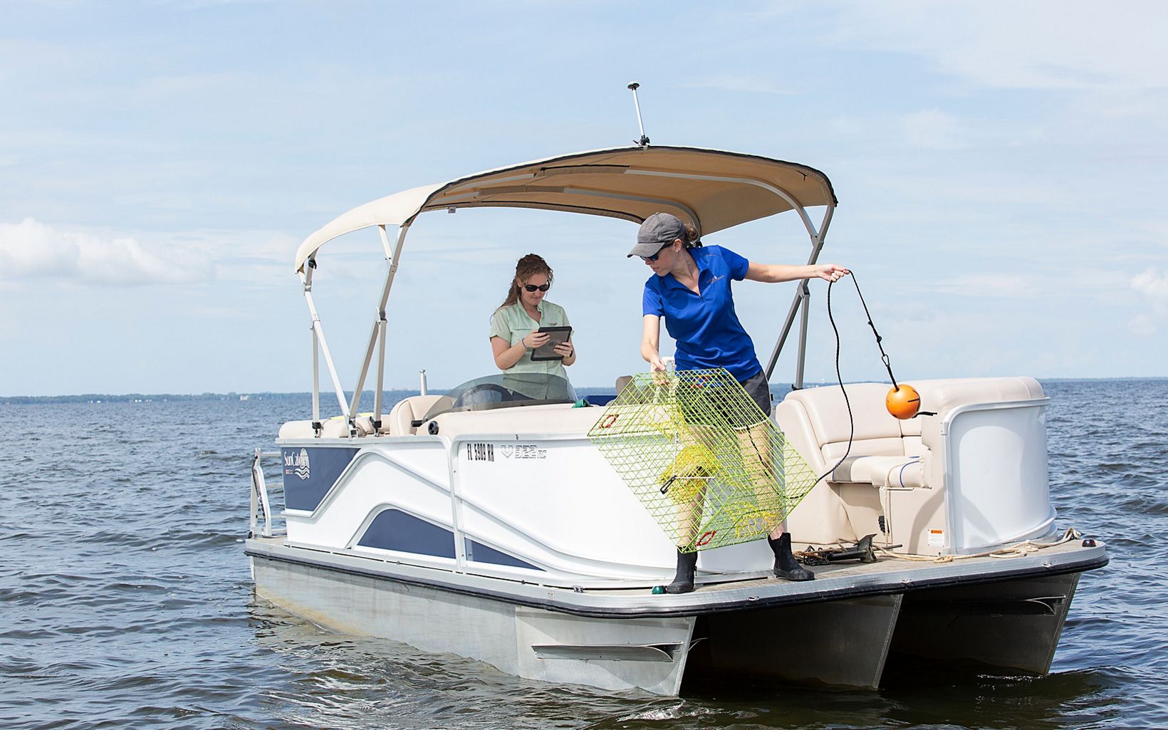 Scientists conducting oyster reef restoration monitoring travel in a boat on Pensacola Bay. 