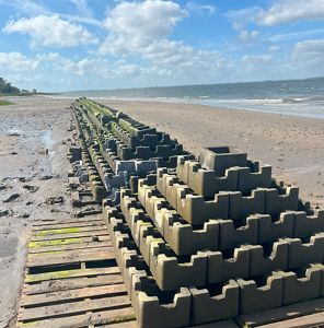 Coastline with stacks of gray concrete blocks.