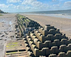 Coastline with stacks of gray concrete blocks.
