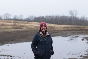 Michelle Pressel standing in front of wetlands and trees.