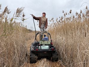 Person standing on agro ATV demoing spraying invasive plants.