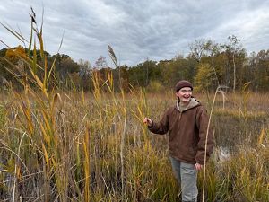 A field with wetlands and a person laughing.