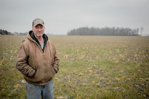 Jeff Duling stands in agricultural field with gray sky.