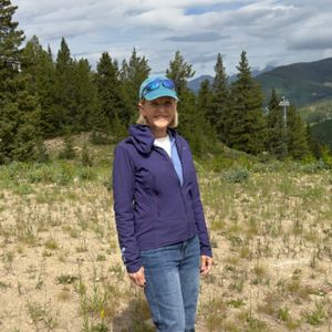 Nancy Gotfredson stands in a forested area.