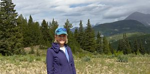 Nancy Gotfredson stands in a forested area.