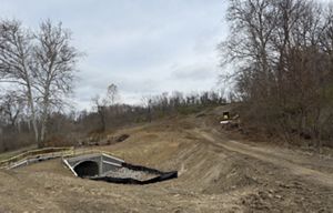 Dirt hills with yellow equipment in the background.
