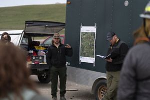 Man stands by trailer with map attached. 