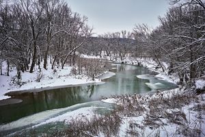 A snow-covered river at Creek's Bend Overlook during winter.