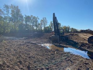 Machinery quipment in mud constructing the stream.