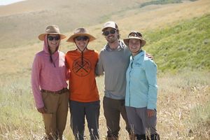 The Nature Conservancy in Wyoming science team standing on a rocky ridge line, looking into the camera and smiling.