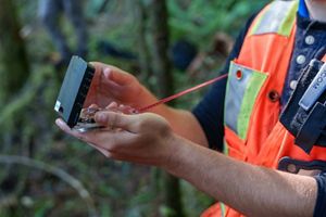 Hands holding forestry measurement tool.