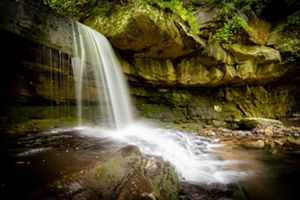 A waterfall flows over rocks.
