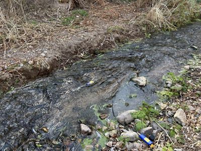 Close shot of a running creek with little blue probes collecting data from it.