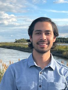A headshot of Will Helt in front of a wetland. 