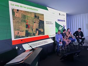 Un panel de cuatro hombres haciendo una presentacion con una pantalla digital en el fondo.