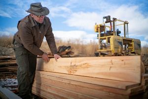 Mark Stosich examines wood planks.