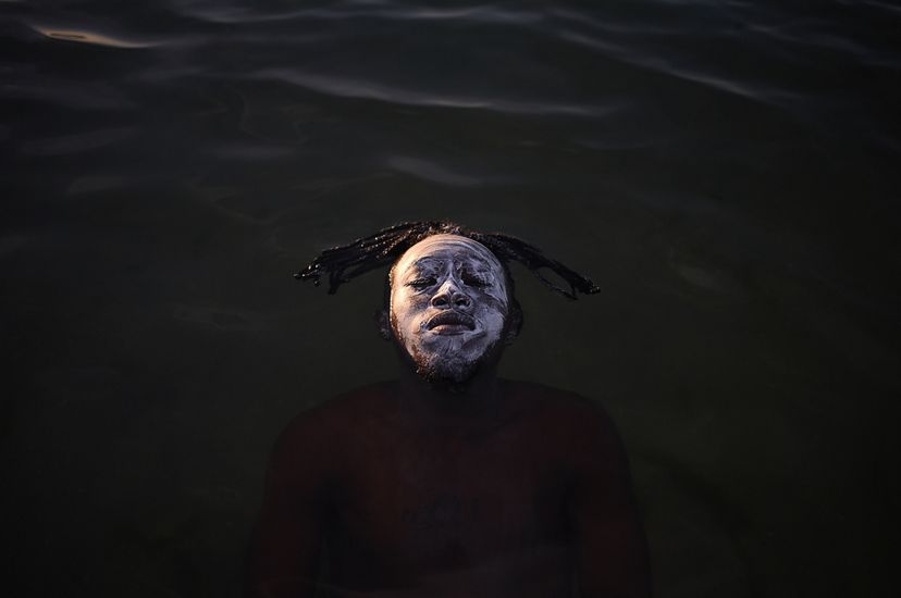 A young African refugee from the Democratic Republic of Congo floating in the waters of Guanabara Bay, Ramos Beach.