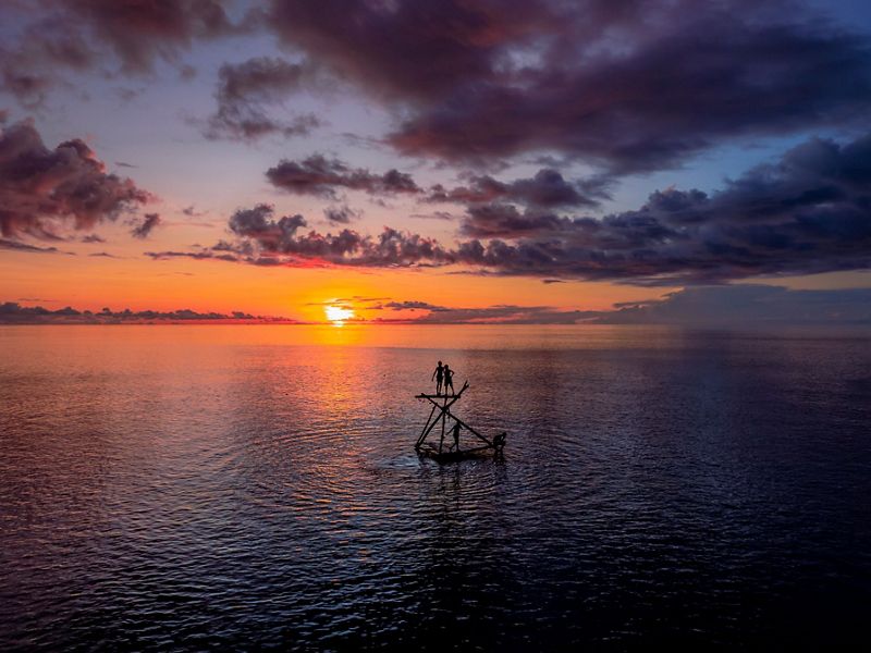 People on a platform in the middle of a wide expanse of water.