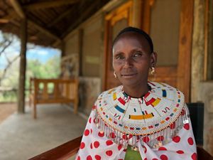 Peresina Lesingiran showing off the eco-lodge she and her community built. © Mike Pflanz