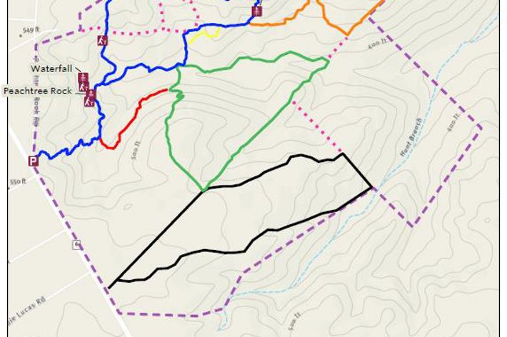 A trail map of a preserve includes red lines to reveal trails and green blobs to identify nature.