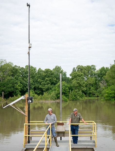 Two men wearing hats stand on a platform.