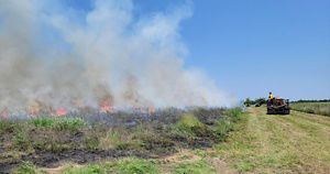 Smoke is rising over the grassland as TNC burn crews monitor the burn.
