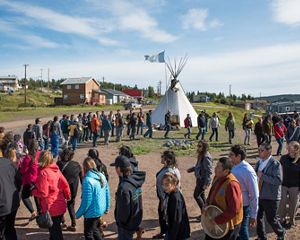 people stand in a circle around a fire in the northwest territories of canada