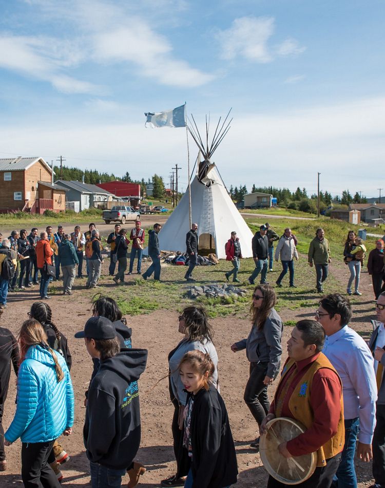 a group walks around in a circle at a fire ceremony