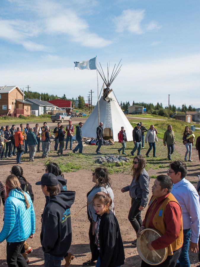 a group walks around in a circle at a fire ceremony