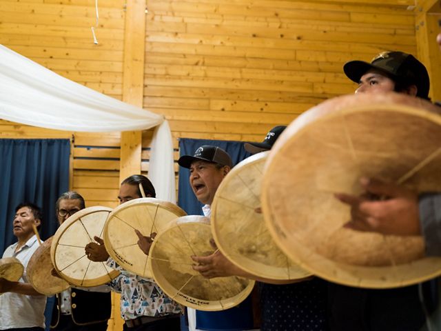 first nation native american men beating drums during a ceremony 