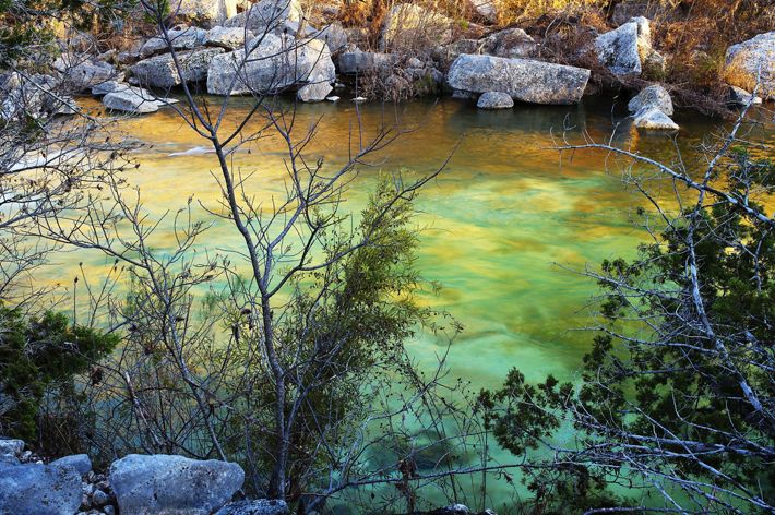 A river cuts through hills and shrubs.