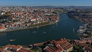 Aerial view of Portuguese city with river running through urban area.