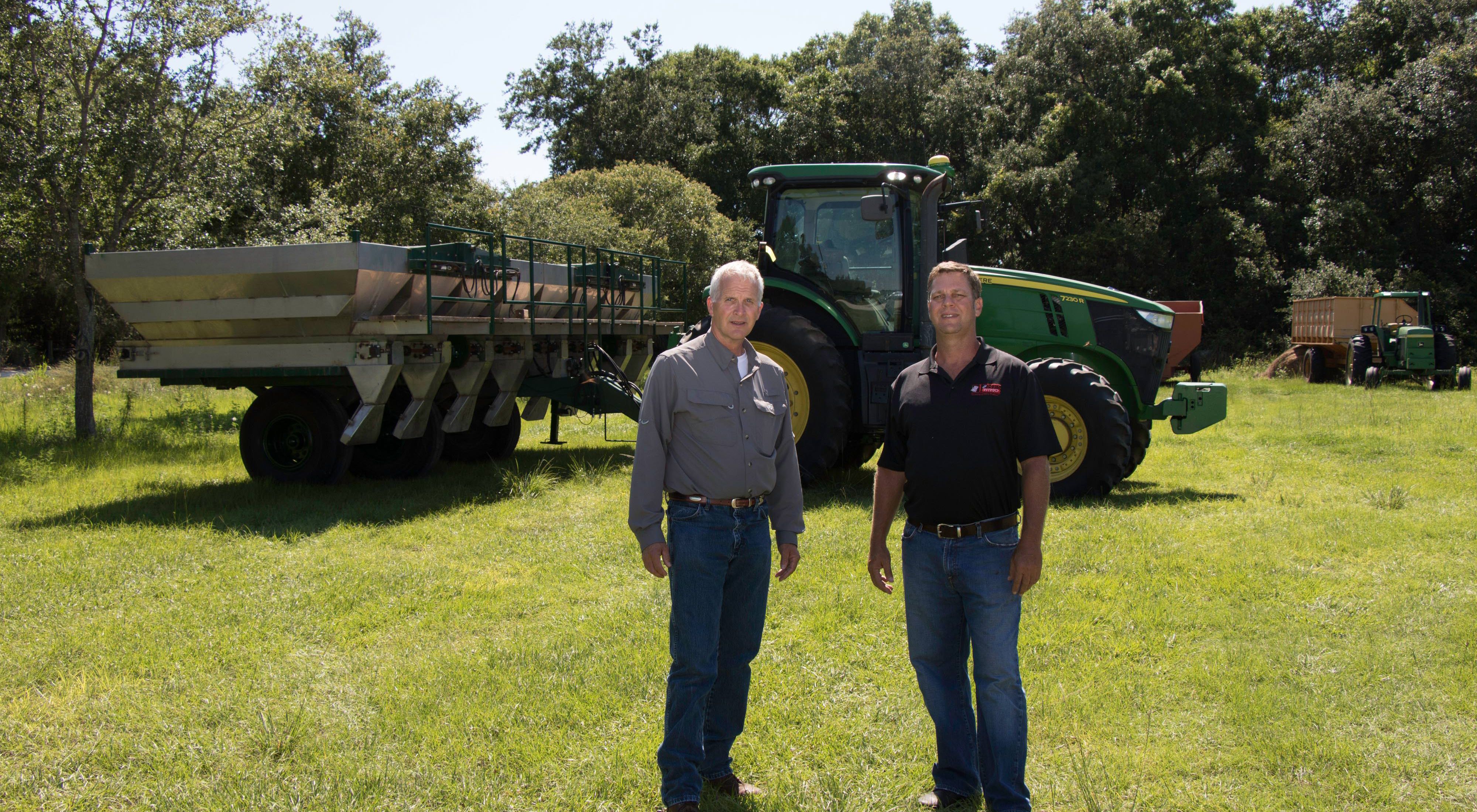 Alan Jones (right) and David Royal, nutrient stewardship manager for The Nature Conservancy in Florida,  in front of a GPS fertilizer drop spreader at Jones Farm.