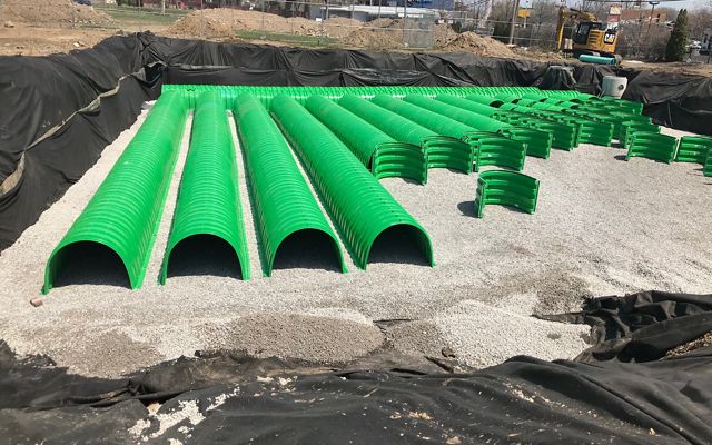 Green underground cistern tubes being layed out in a grid.