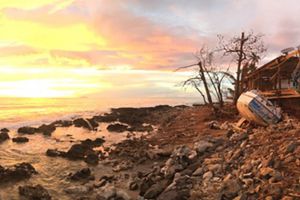 A post-hurricane eroded shoreline against a sunset