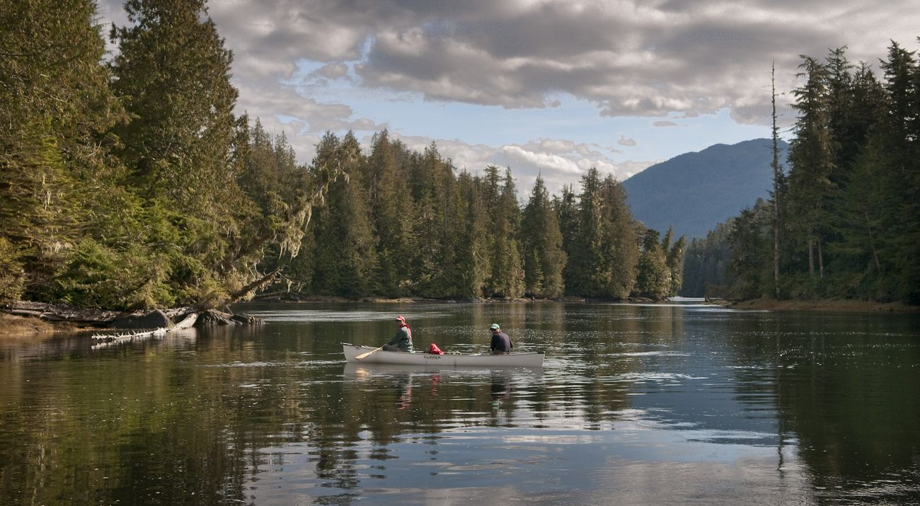 Two people canoeing on a river.