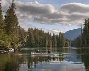 Two people canoeing on a river.