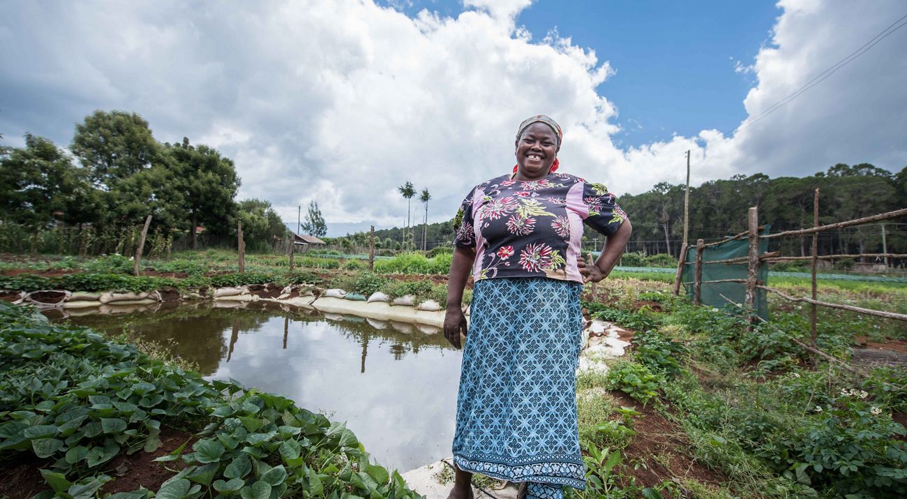 a woman standing in front of a tea farm.