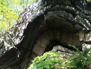 An arched rock formation leading into a cave under the arch.