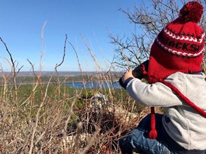 child with binoculars looking out at Rattlesnake Ridge