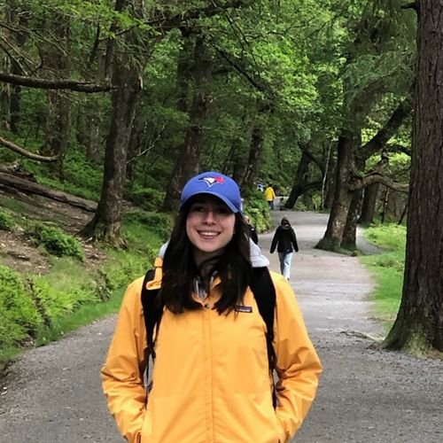 Person in raincoat standing in a park.