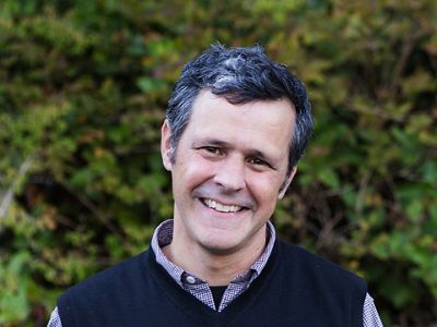 Person in a button up shirt and vest.