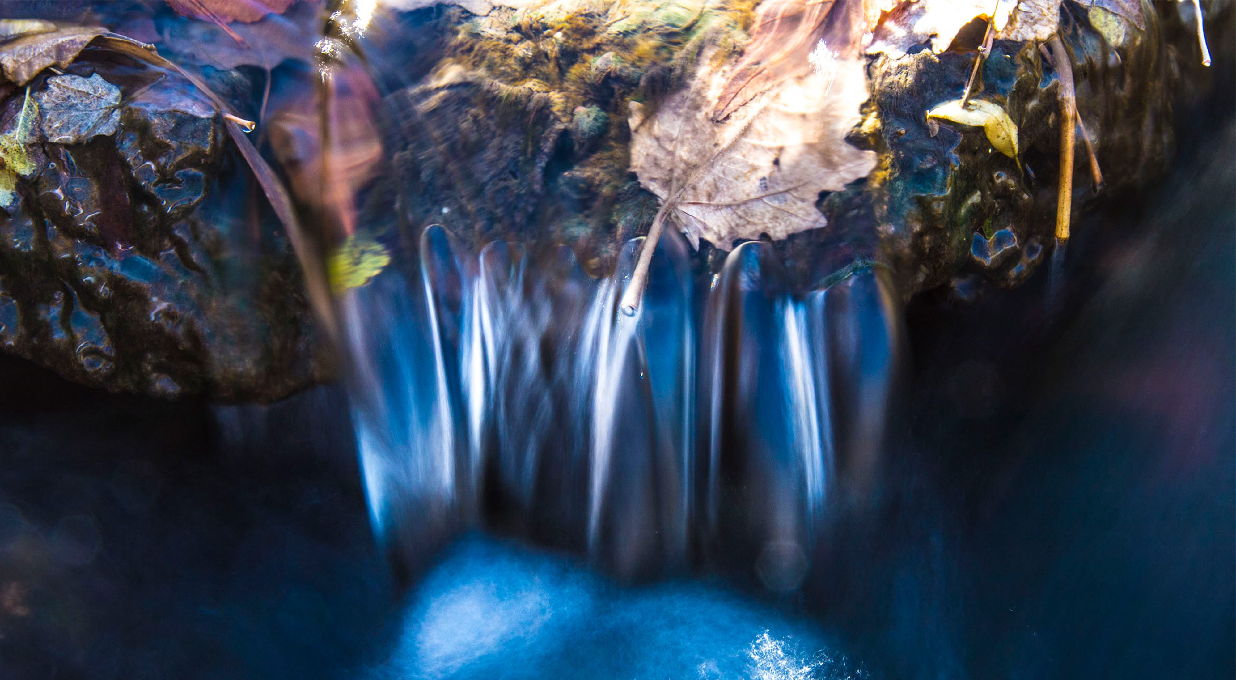 A small waterfall in a blue creek close up