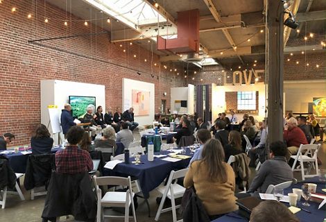 An audience listens to a group engaged in a panel discussion at an RCIS Symposium.