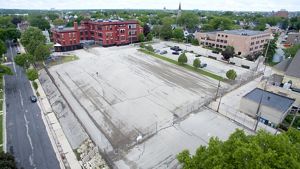 A brick school building surrounded by concrete.