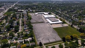 An aerial view of a school with a concrete schoolyard and very little green space.