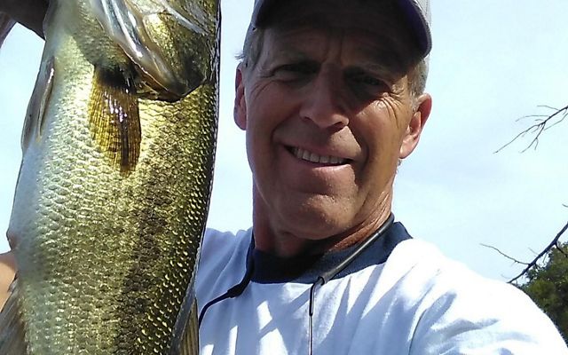A selfie of a man holding a large fish.